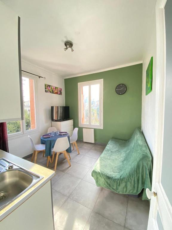 une cuisine avec évier et une chambre avec table dans l'établissement Appartement PALOMA Proche Cannes, au Cannet