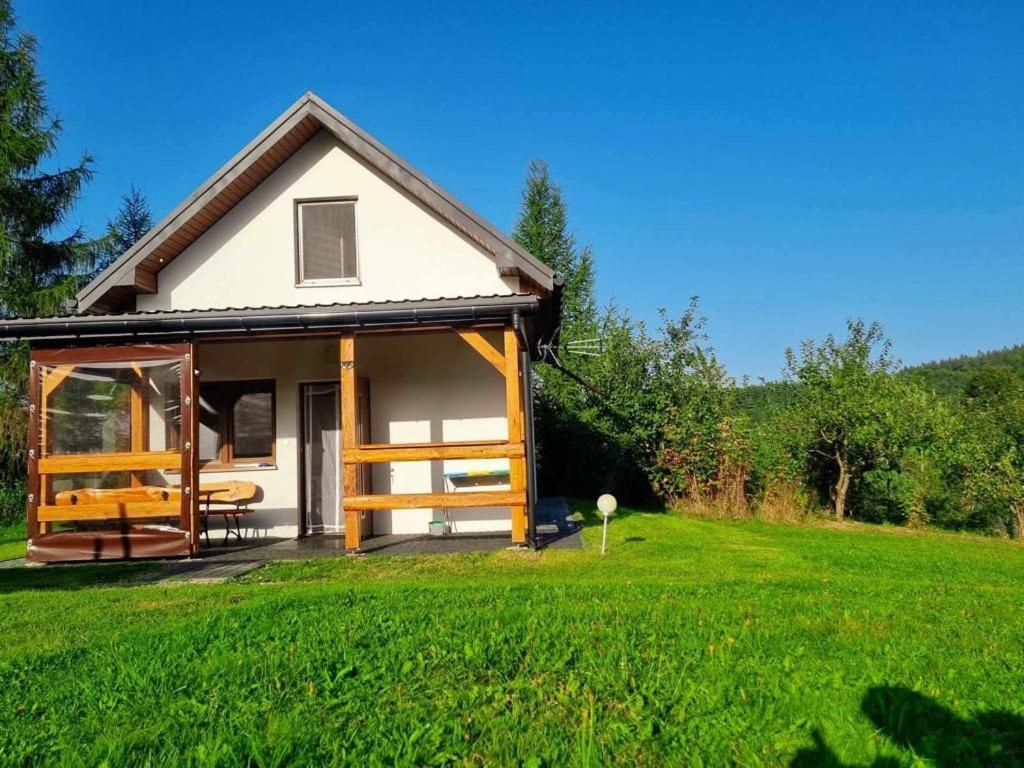 a small house in a field with green grass at Bieszczadzki domek in Wola Matiaszowa