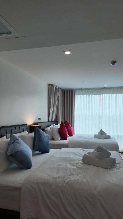 a hotel room with two beds with pillows on them at Kashouse hatyai in Ban Khlong Pleo