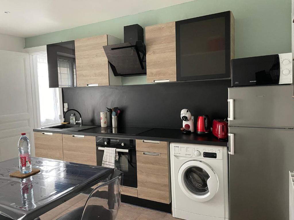 a kitchen with a refrigerator and a washing machine at Meublé 42 m2 à Vittel proche Thermes-SPA in Vittel