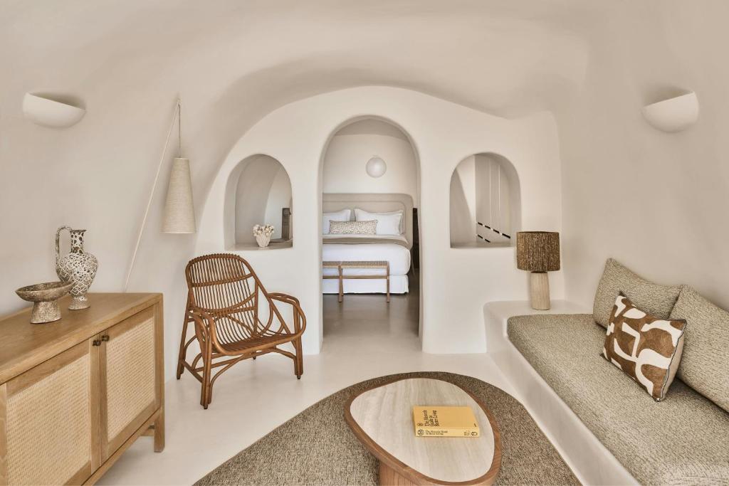 salon z kanapą i łóżkiem w obiekcie Mystique, a Luxury Collection Hotel, Santorini w mieście Oia