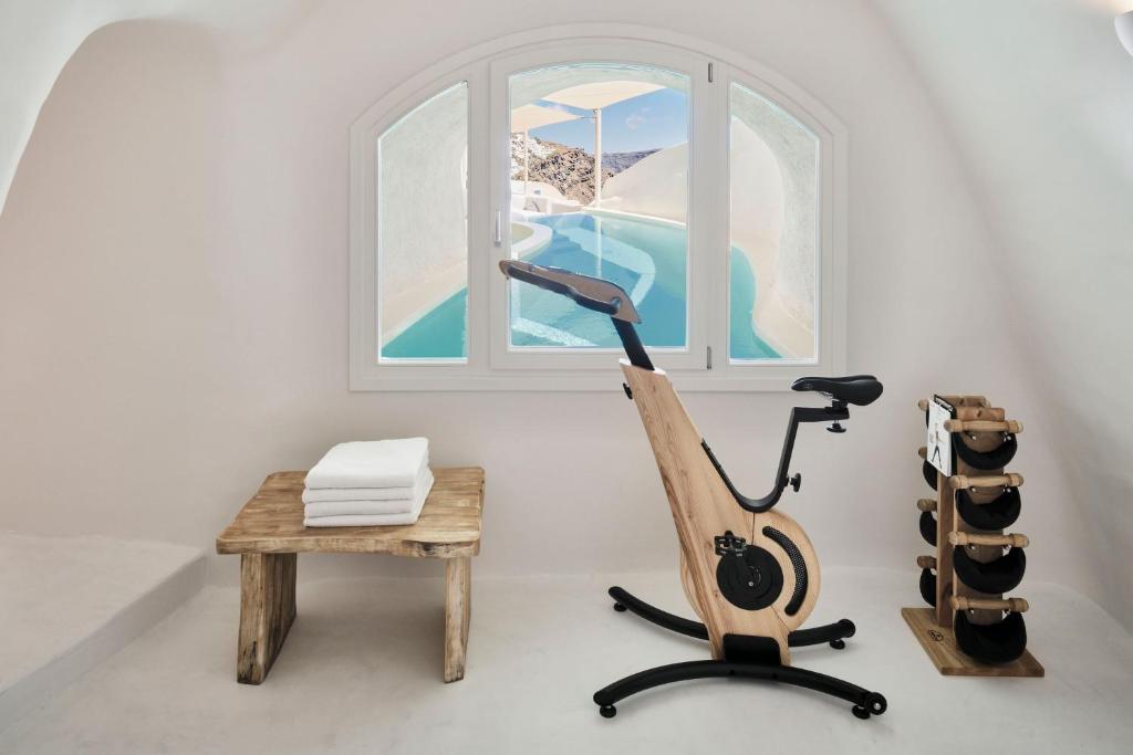 pokój z rowerem treningowym obok okna w obiekcie Mystique, a Luxury Collection Hotel, Santorini w mieście Oia