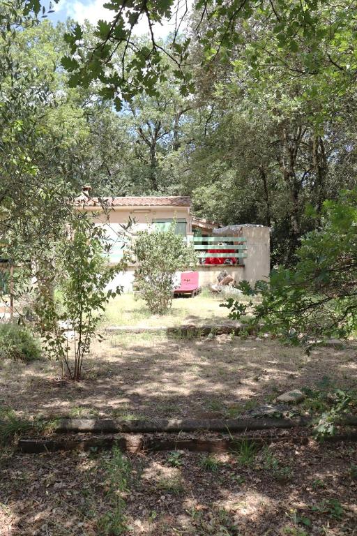 un bâtiment au milieu d'un champ avec des arbres dans l'établissement Mazet la Clé des FLOTS en bord de rivière, à Collias