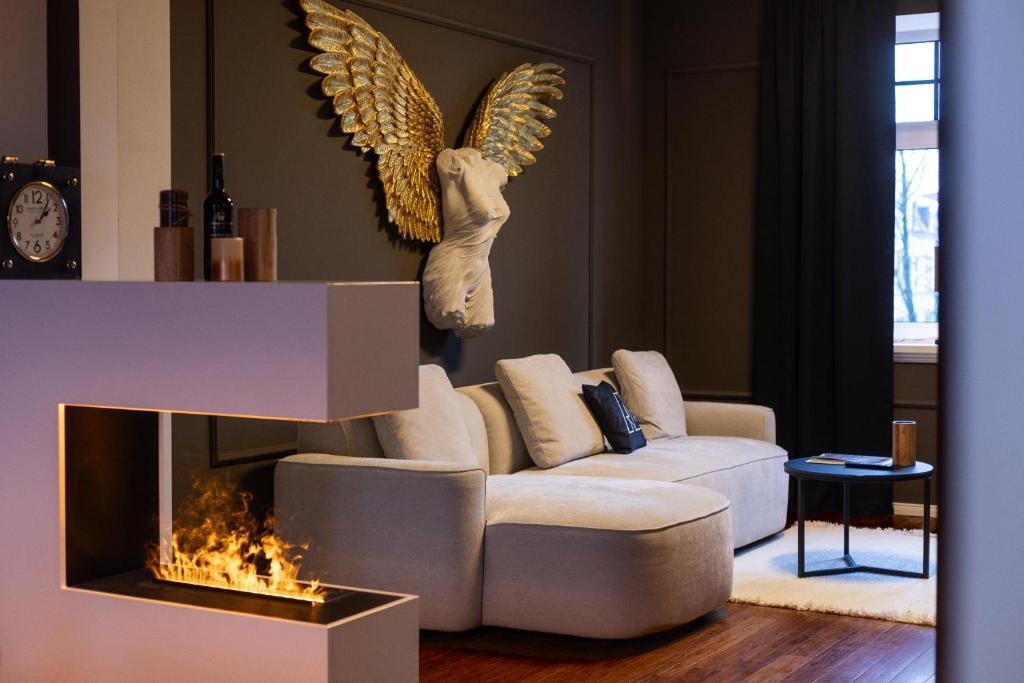 a living room with a couch and an angel head on the wall at Mokka Suite Design in Neumünster in Neumünster