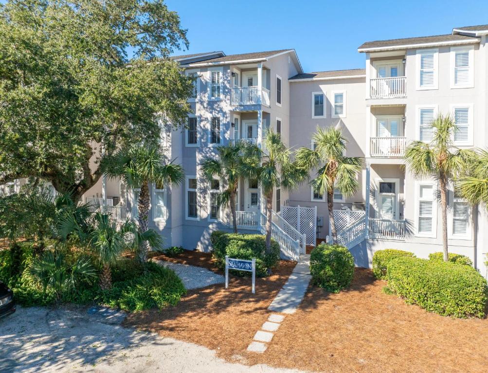 an apartment building with palm trees in front of it at SeaHaven, Unit 1529 - 1529 Wood Ave in East End