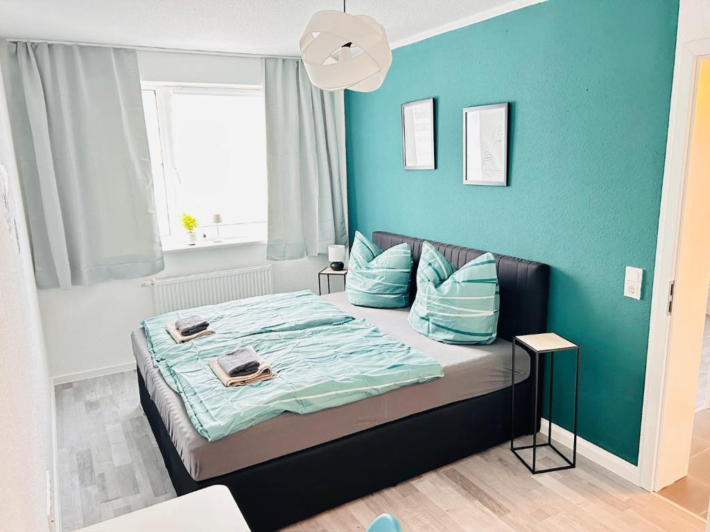 a bedroom with a bed with a blue wall at CLUBHAUS 6 - geräumige Ferienwohnung mit 4 Schlafzimmern & 2 Bädern in Worbis