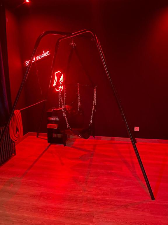 une chambre rouge avec une scène et une lumière rouge dans l'établissement Hom & Love, Love Room BDSM, à Homécourt