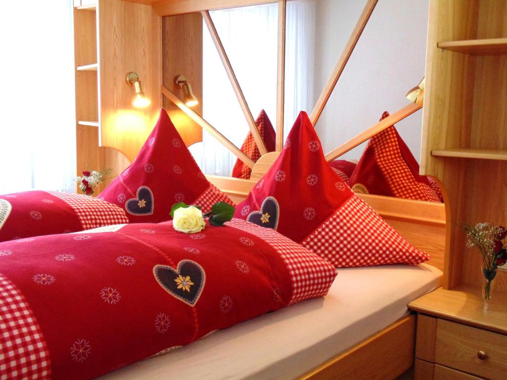 a bedroom with red pillows on a window ledge at Uschi's Steinröschen in Fischen
