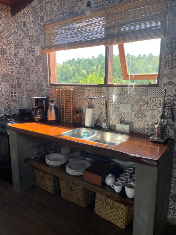 a kitchen counter with a sink and a window at Medio Cielo Cabaña de Montaña in Rincón de Luna