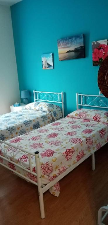 a bed in a room with a blue wall at B&B Il Faraglione Bianco in Vieste