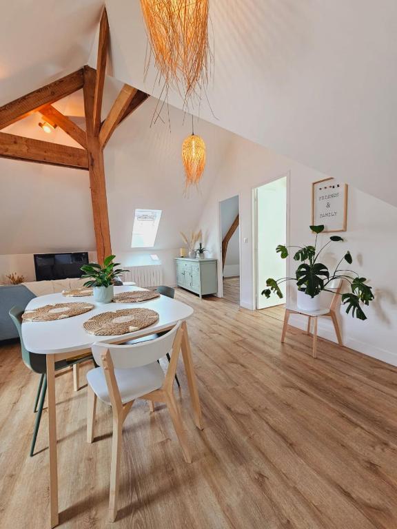 un salon avec une table et des chaises blanches dans l'établissement Appartement Vanille, à Pontivy