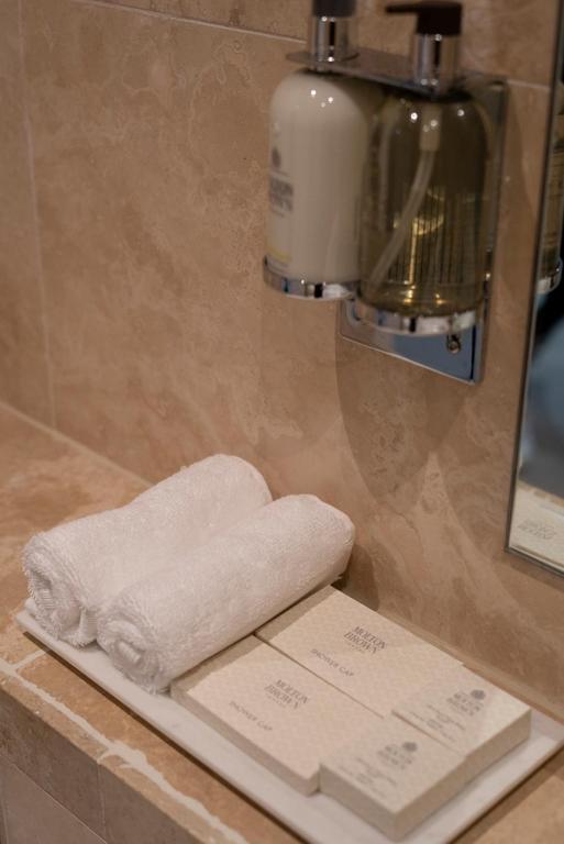 a pile of towels on a shelf in a bathroom at 40 Winks Hospitality in Durham