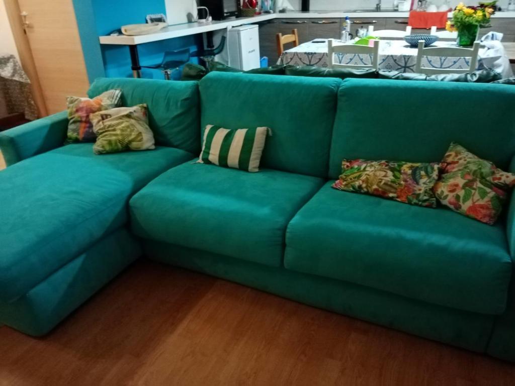 a blue couch with pillows on it in a room at B&B Il Faraglione Bianco in Vieste