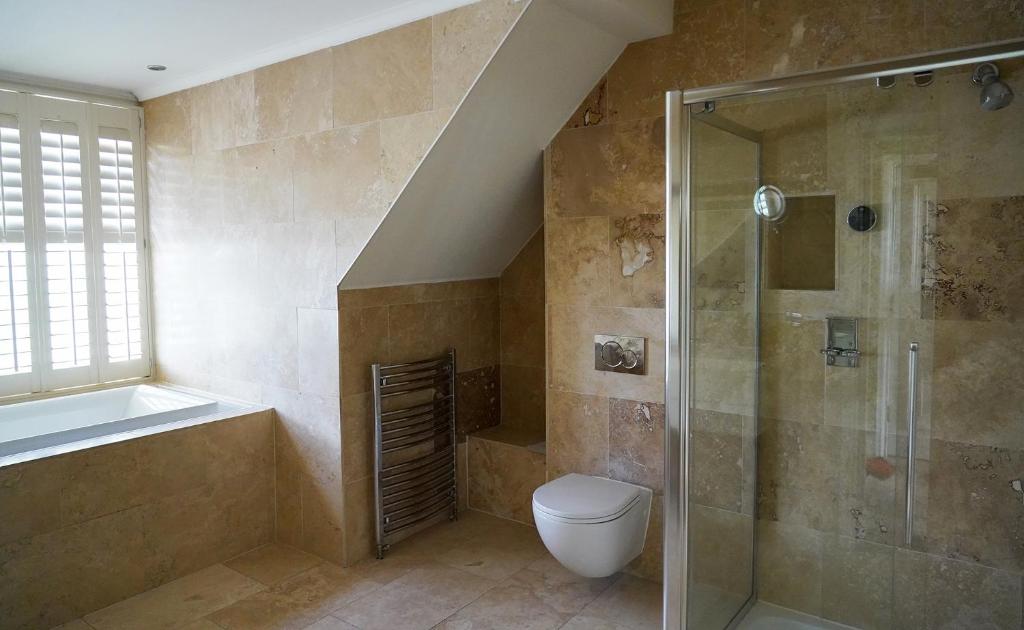 a bathroom with a shower and a toilet and a sink at 40 Winks Hospitality in Durham