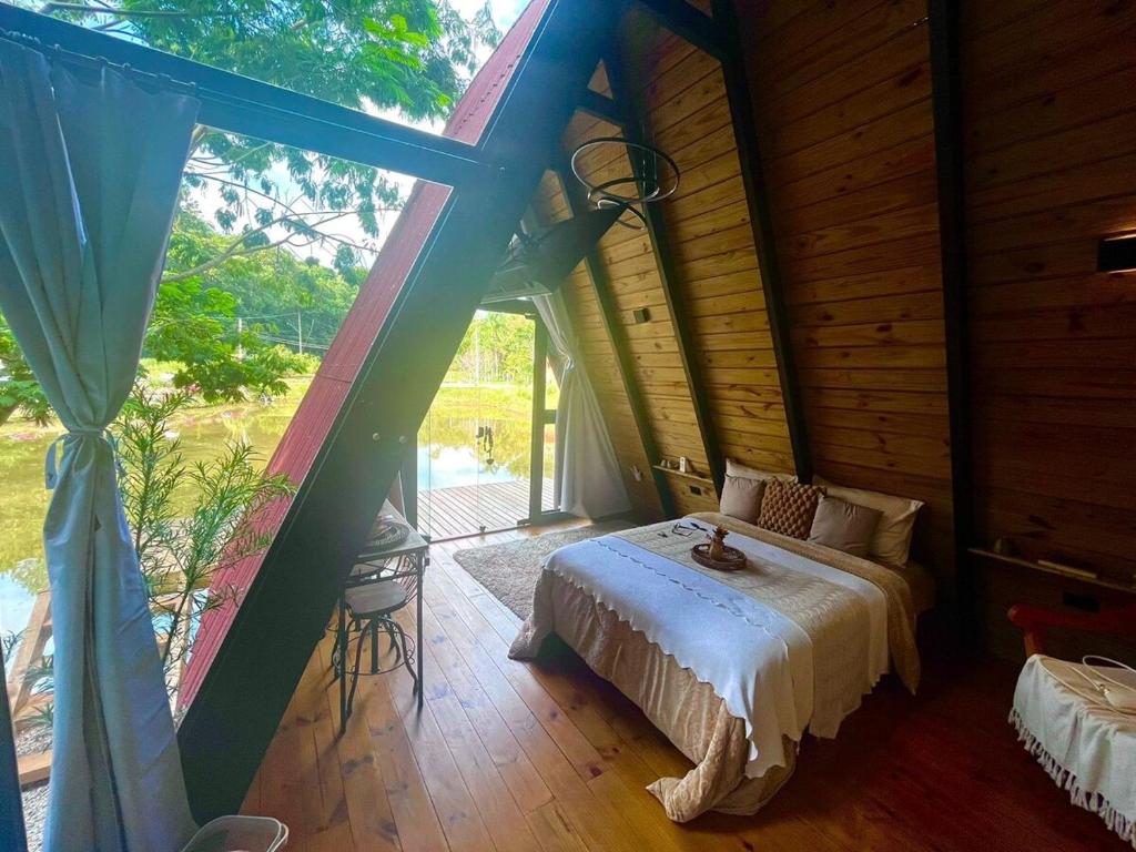 una camera da letto con un letto e una grande finestra di Sitio Lar da Terra a São Roque