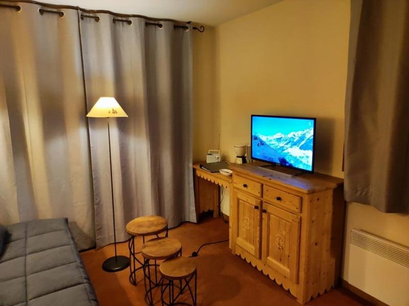 - un salon avec une télévision et un bureau avec des chaises dans l'établissement Superbe T2 classé 3 étoiles bien situé, à Villarembert