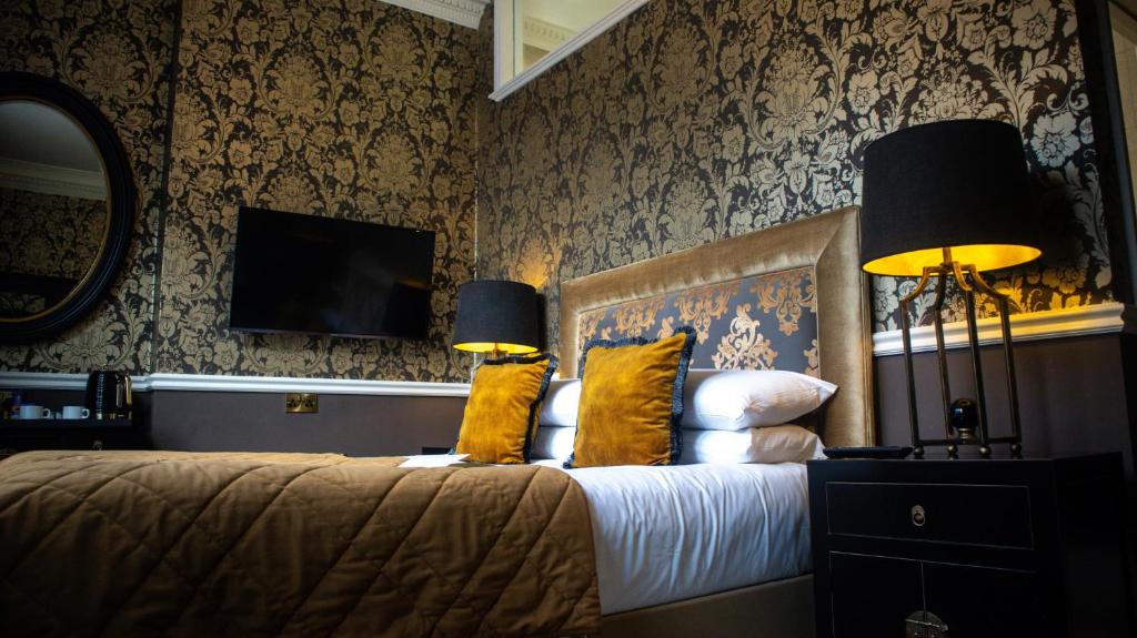a bedroom with a bed with two lamps and a tv at 40 Winks Hospitality in Durham