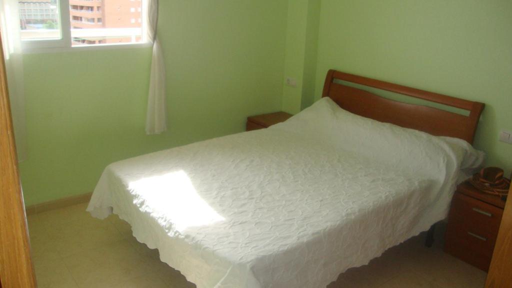 Un dormitorio con una cama blanca y una ventana. en Marinador 1, en Oropesa del Mar