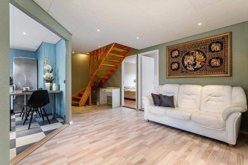 a living room with a white couch and a staircase at Pärnu Spa Duplex for 8 in Pärnu