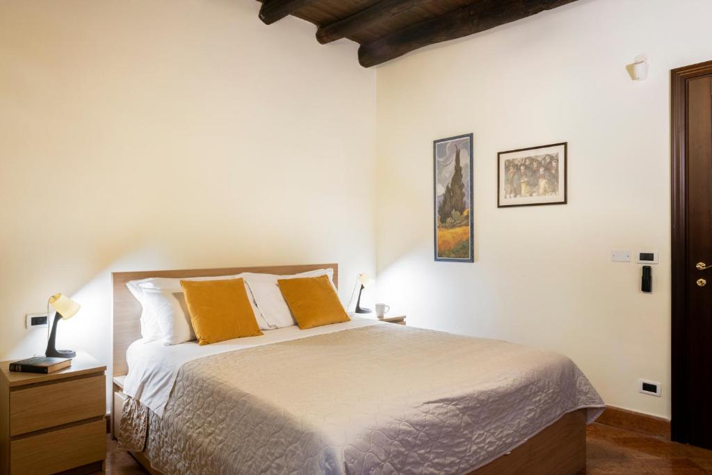 una camera con un letto con due cuscini arancioni di I Carrettieri - a few steps from the Cathedral a Palermo