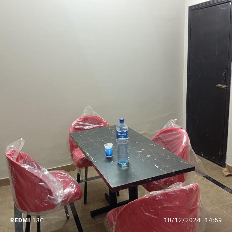 a bottle of water sitting on a table with red chairs at 5 Marla safari valley bahria Phase 8 in Rawalpindi