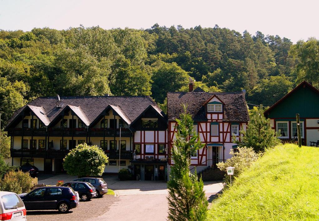 eine Gruppe von Häusern mit Autos auf einem Parkplatz in der Unterkunft Baunhöller-Mühle in Emmelshausen