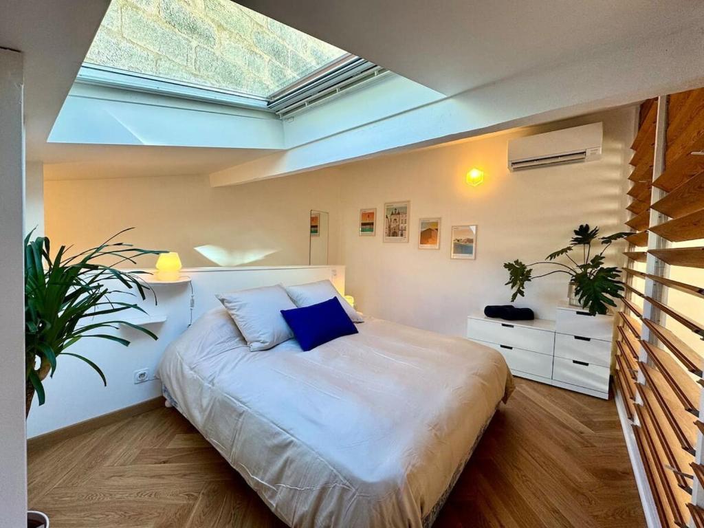 - une chambre avec un grand lit et une lucarne dans l'établissement Nid douillet - Maison tout équipée, à Bordeaux