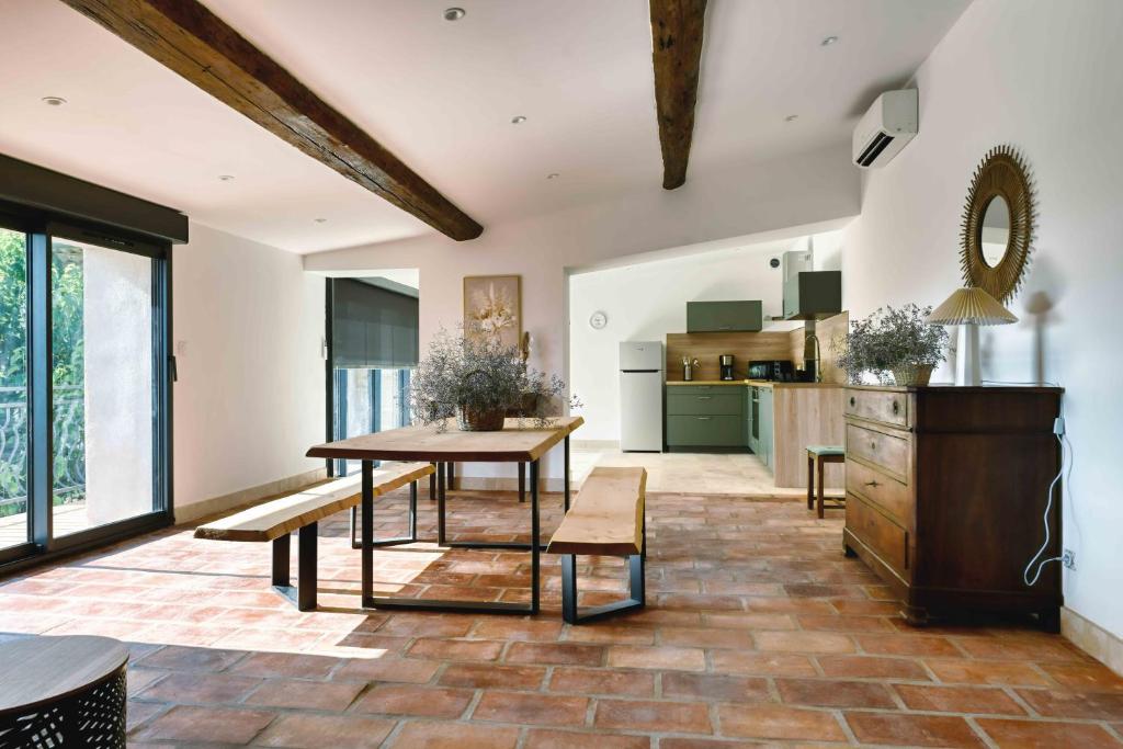 un salon avec une table et une cuisine dans l'établissement Maison Rénovée, Vue sur Nature, à Fontanès
