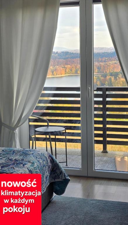 Postel nebo postele na pokoji v ubytování ,,KICZARA"Pokoje w Polańczyku z klimatyzacją, widokiem na Jezioro Solińskie i góry 6018-06-454
