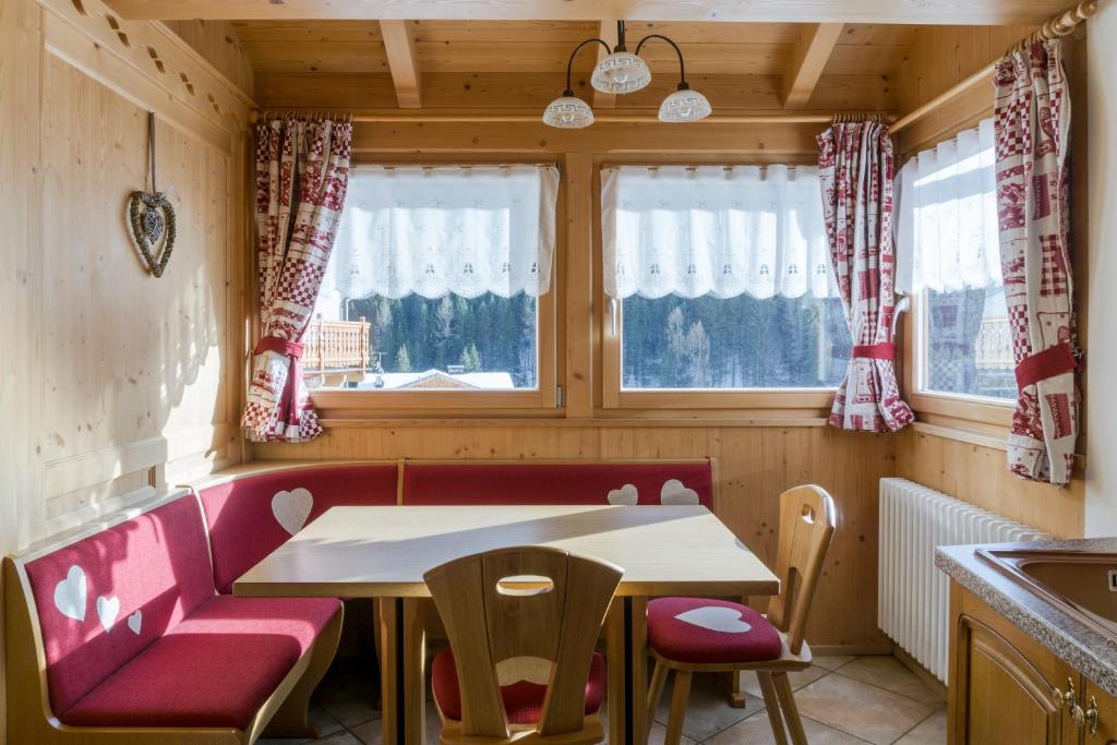 a small kitchen with a table and a red couch at Dolomites with Love in Mazzin