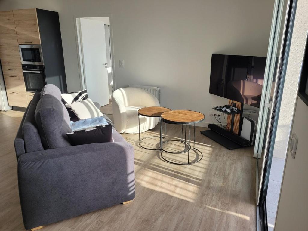un salon avec un canapé et une table dans l'établissement T2 récent, tout équipé et bel extérieur, à Quimper