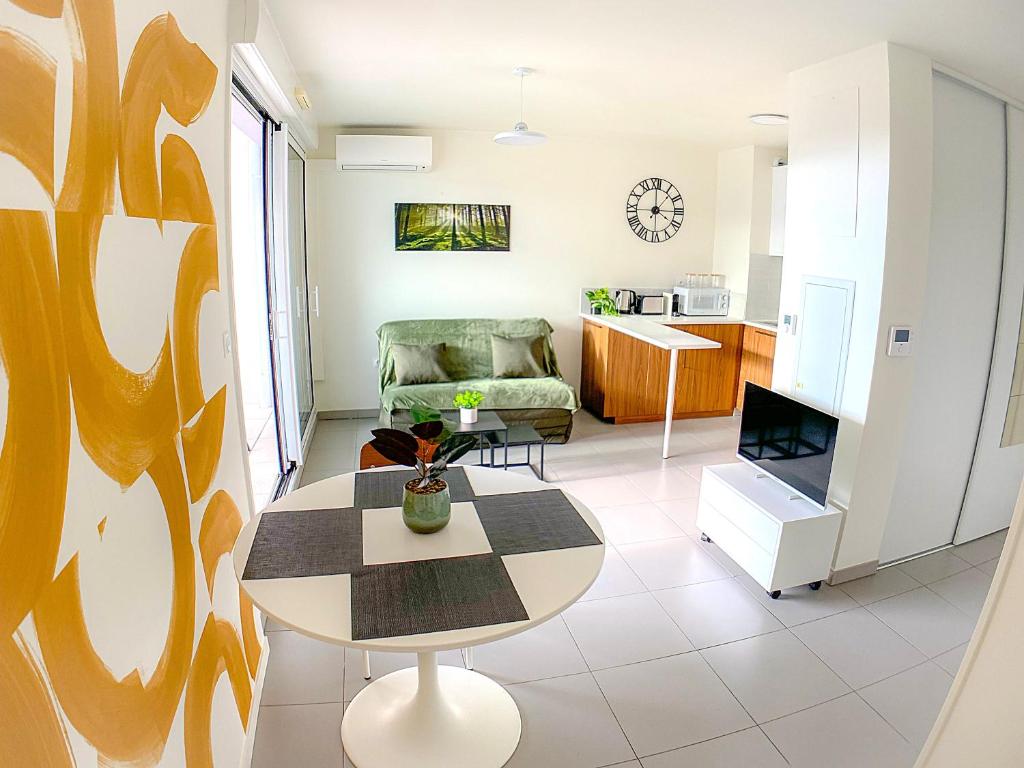 un salon avec une table et une chaise dans l'établissement T2 Coeur de Ville Montpellier Proche Port Marianne, à Montpellier