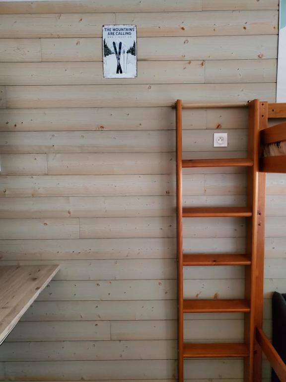 un mur dans une pièce avec une échelle et un panneau dans l'établissement Studio en montagne, à Besse-et-Saint-Anastaise