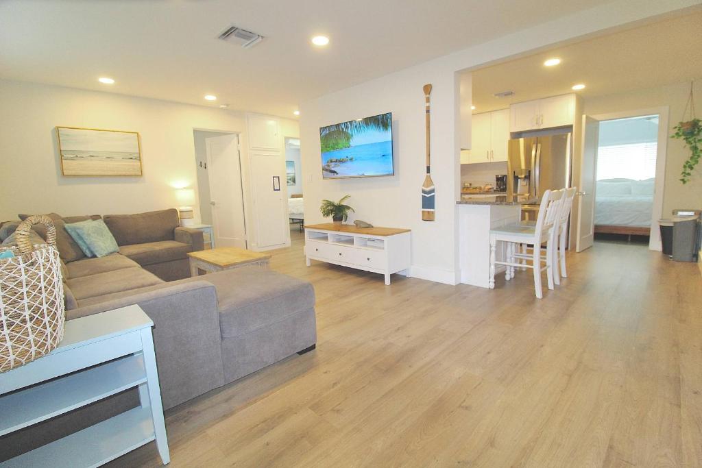 a living room with a couch and a kitchen at Jensen Surf Shack in Jensen Beach