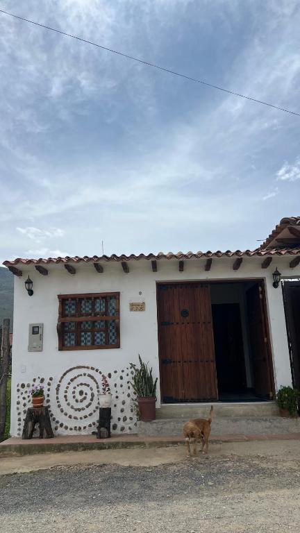 un perro parado frente a una casa en La Caracola, en Villa de Leyva