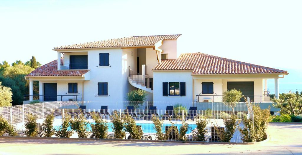 dom z basenem przed nim w obiekcie Les Terrasses Du Grand Large w mieście Porto Pollo
