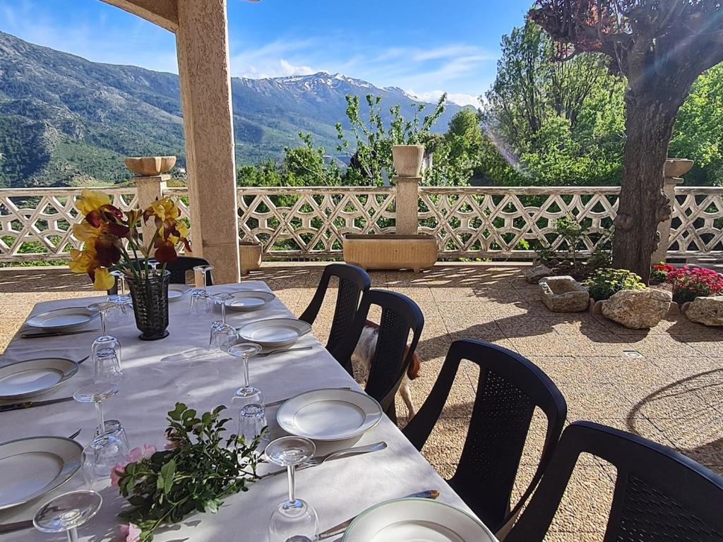 - une table avec des assiettes et des verres à vin sur la terrasse dans l'établissement Villa avec vue panoramique sur les montagnes, à Corscia