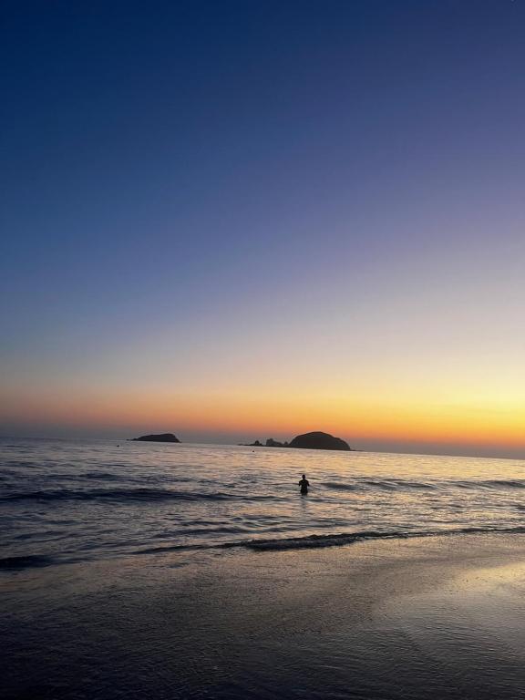 una persona che nuota nell'oceano al tramonto di Condominio Flamingos a Ixtapa