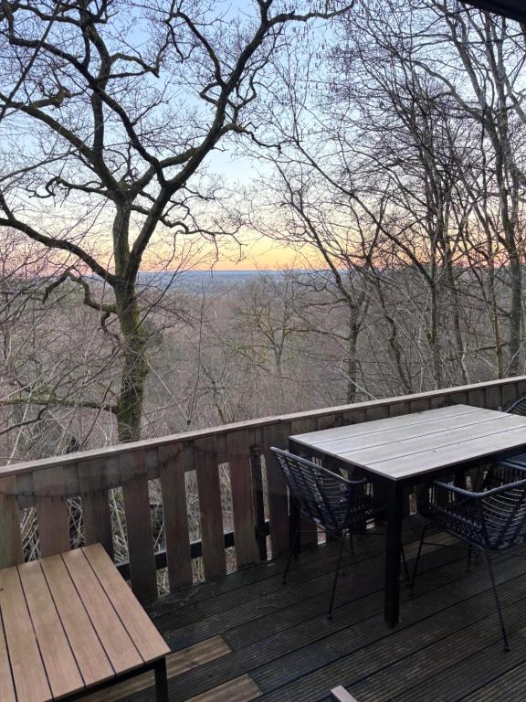una mesa y sillas en una terraza con vistas en The Forest Cabin Durbuy, en Durbuy