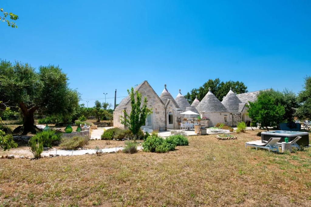 una fila di cottage con un tavolo da picnic in un cortile di Apulia Trulli Macco Macco Locorotondo a Locorotondo