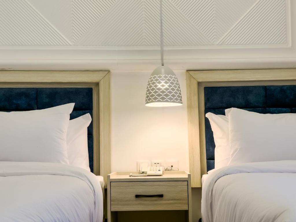 Postel nebo postele na pokoji v ubytování Petra Karam Hotel