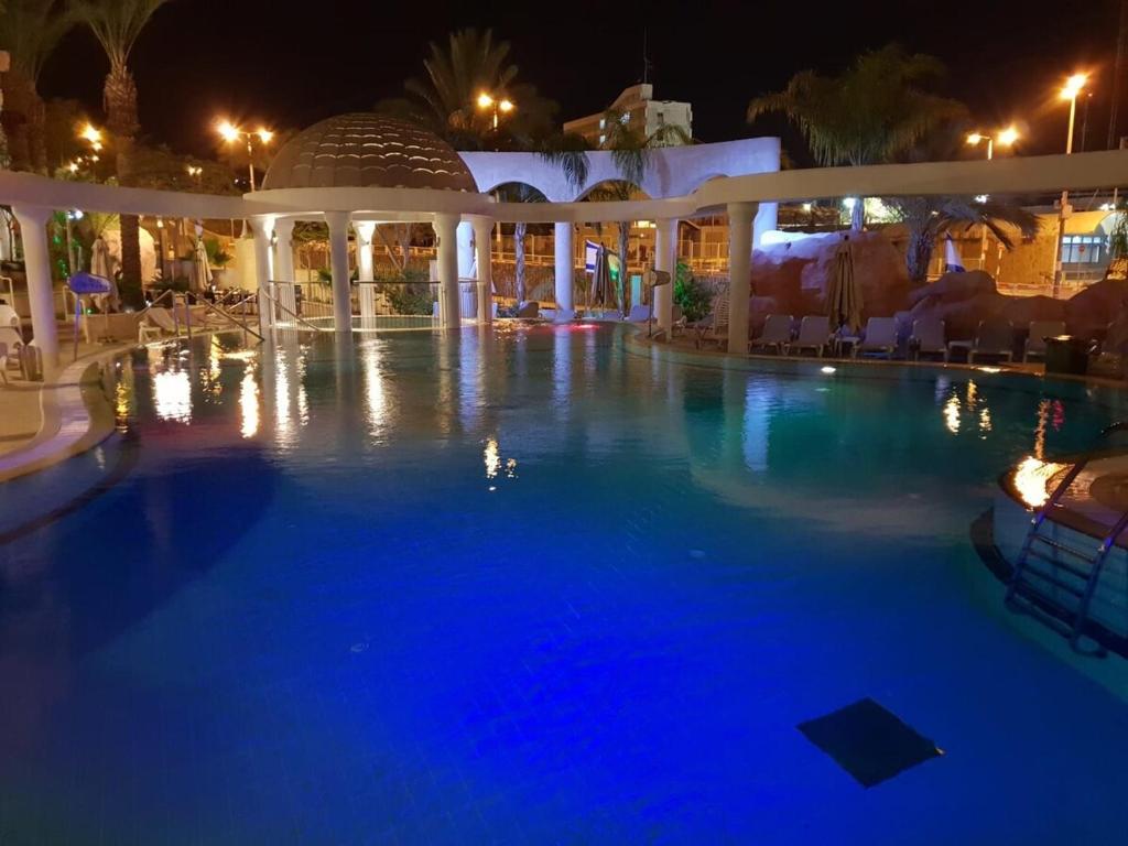 a large swimming pool at night with blue lights at New on booking Top Class Excluzive Luxury De -Golf Resort in Eilat