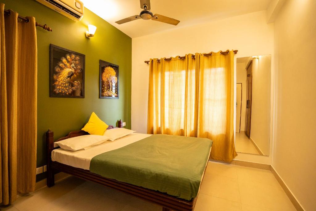 a bedroom with a bed with a window and a mirror at Orange valley Residency Thodupuzha in Thodupuzha