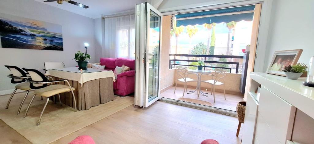 a living room with a pink couch and a table at Moderno y acogedor Parquesol Antequera in Antequera