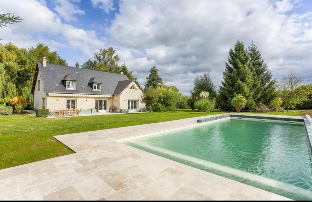 une grande piscine devant une maison dans l'établissement Villa jardin piscine privée, à Saint-Étienne-la-Thillaye