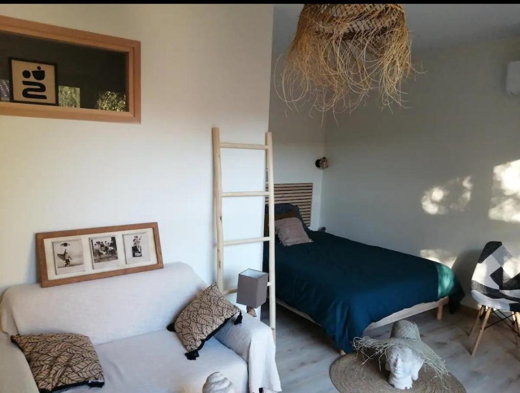 a bedroom with a bed and a chair and a ladder at L'Olivet in Sablet