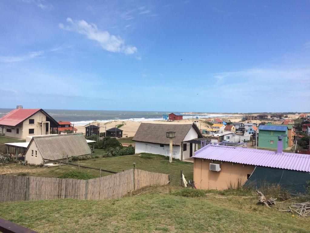 uma pequena cidade com casas e o oceano em The Shark em Punta Del Diablo