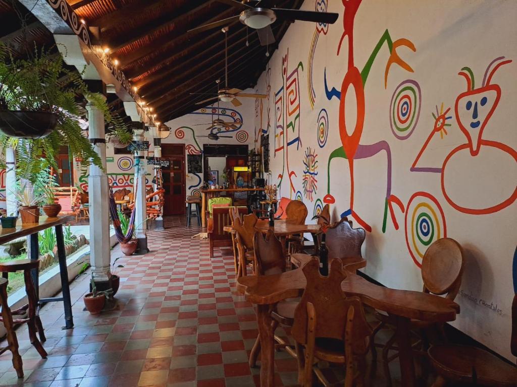 Un restaurante con mesas y sillas y una pared cubierta de grafitis. en Cueva Nica, en Granada