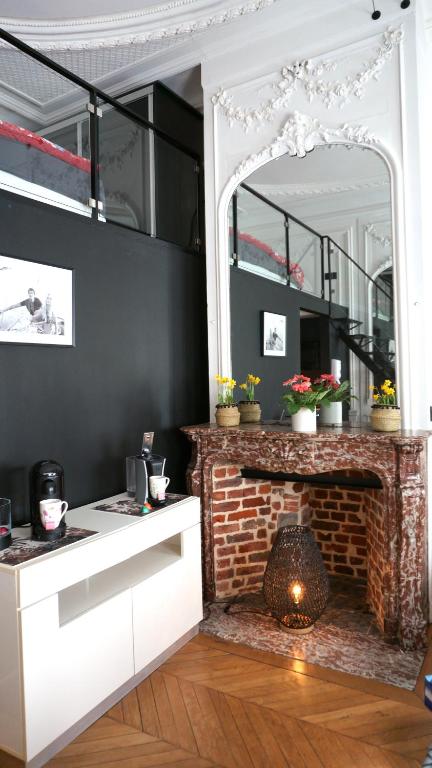 - un salon avec une cheminée en briques et un miroir dans l'établissement Superbe appartement refait à neuf, plein centre de Lille, à Lille