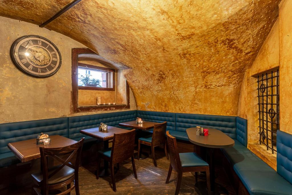 a restaurant with tables and a clock on the wall at Studio Nicolas II Prague in Prague